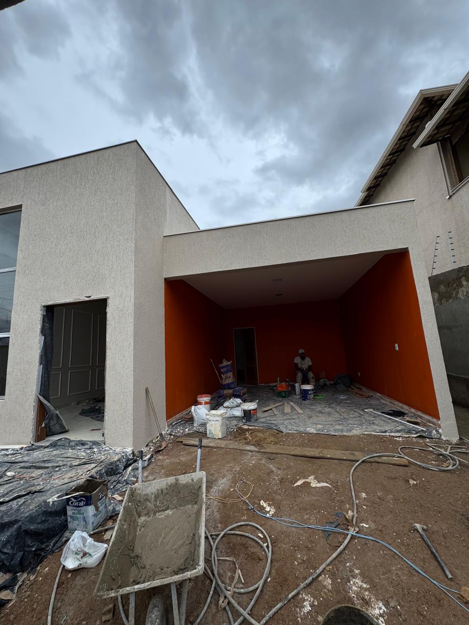 Fachada em fase de acabamento externo, com vão de garagem em destaque